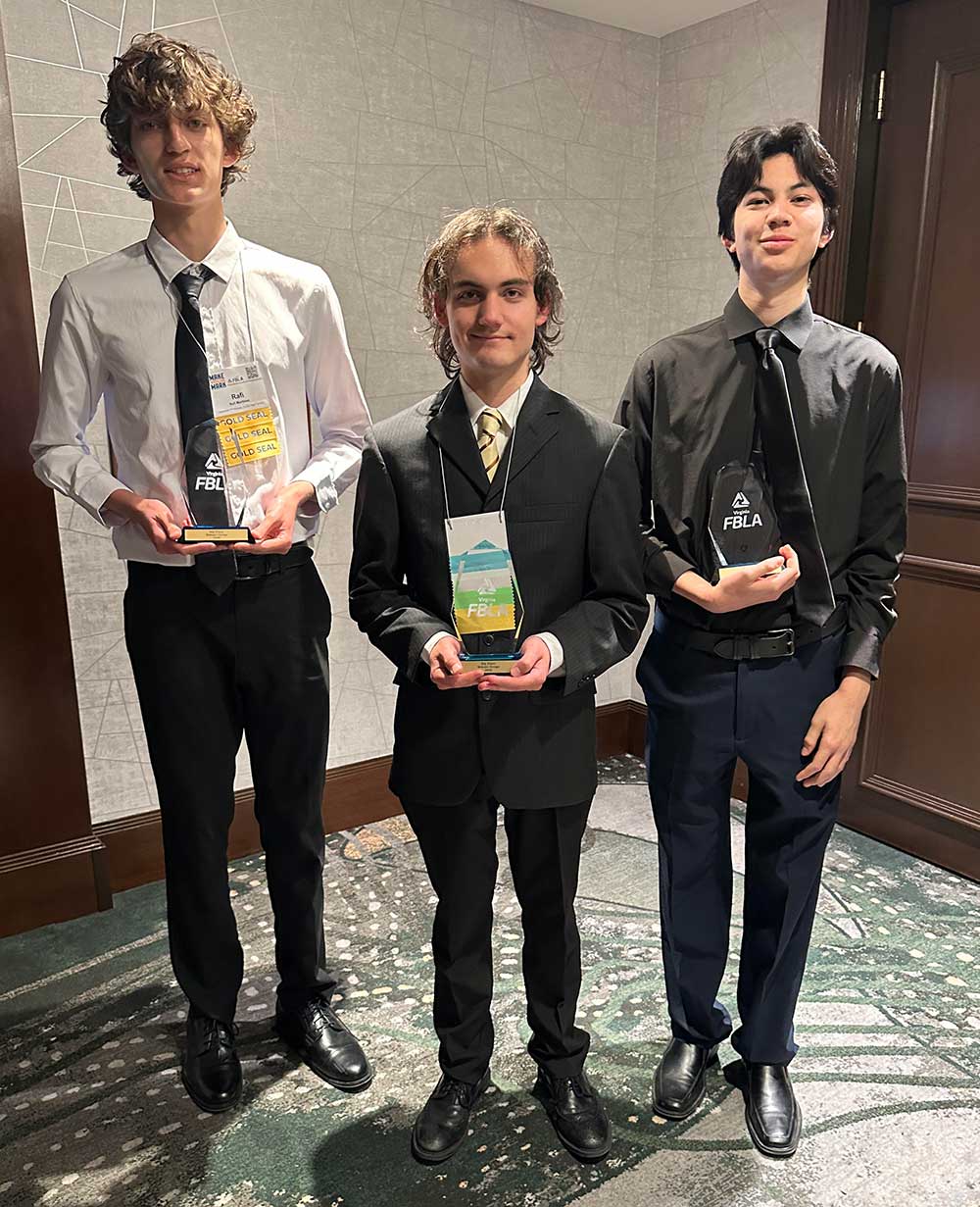Rafi Martinez and his partneres holding an FBLA states trophy
